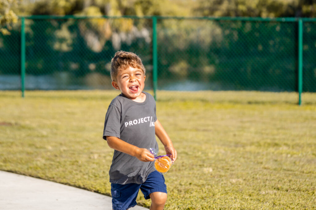 Child with Hunter's Syndrome runs towards the camera during Petland puppy playdate.