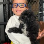 Petland Pembroke Pines picture of child holding cute Petland puppy at SOFLO Battle of Champions.