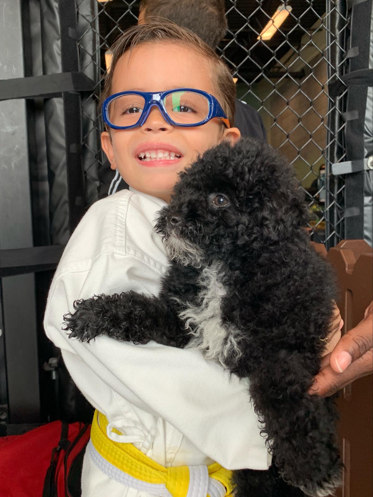 Petland Pembroke Pines picture of child holding cute Petland puppy at SOFLO Battle of Champions.
