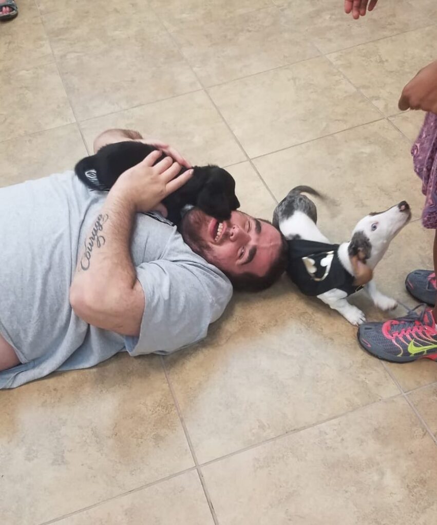 Petland Pembroke Pines picture of Disability Achievement Center patients playing with cute Petland puppies on the floor.
