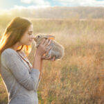 Petland Pembroke Pines picture of a girl holding her pet rabbit in a field.