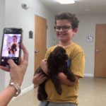 Petland Pembroke Pines picture of child holding a cute petland puppy and taking a selfie photo.