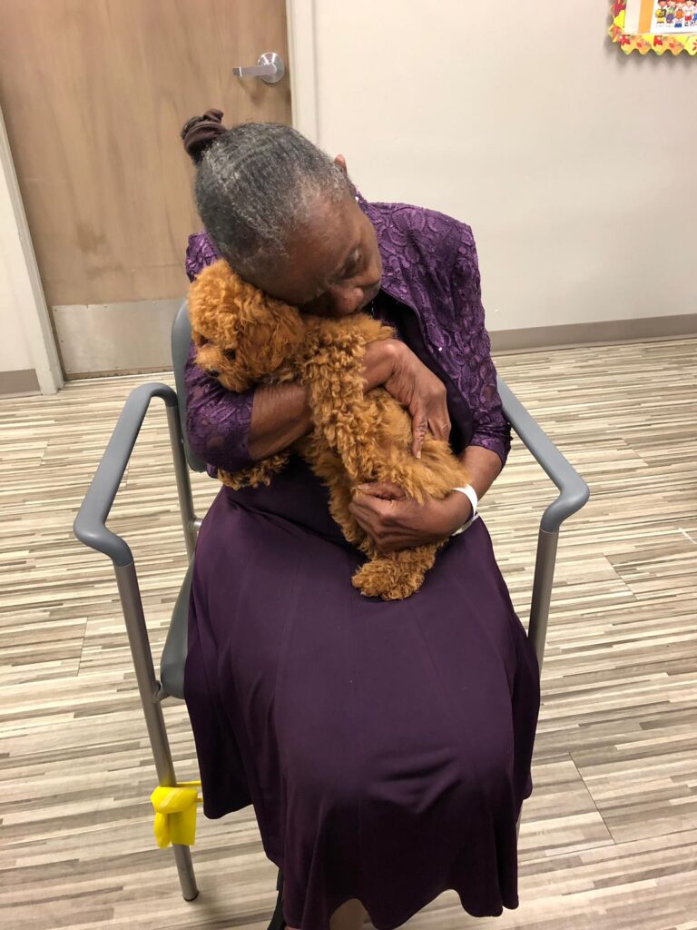 Petland Pembroke Pines picture of patient from Memorial Adult Day Care holding cute Petland puppy.