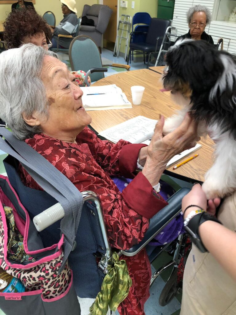 Petland Pembroke Pines picture of patient holding puppy at Southwest Focal Point Senior Center.