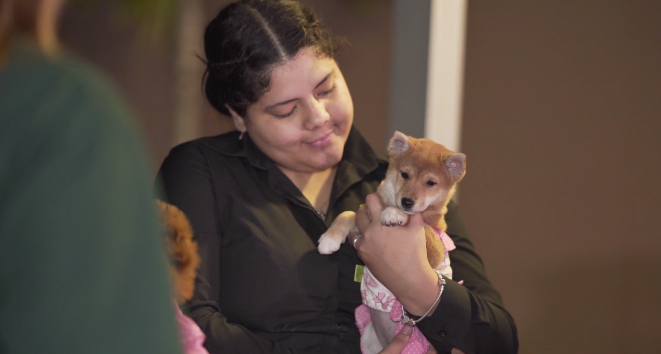 Petland Pembroke Pines picture of a Petland pet counselor holding a cute Petland puppy at WOW Center Block party.