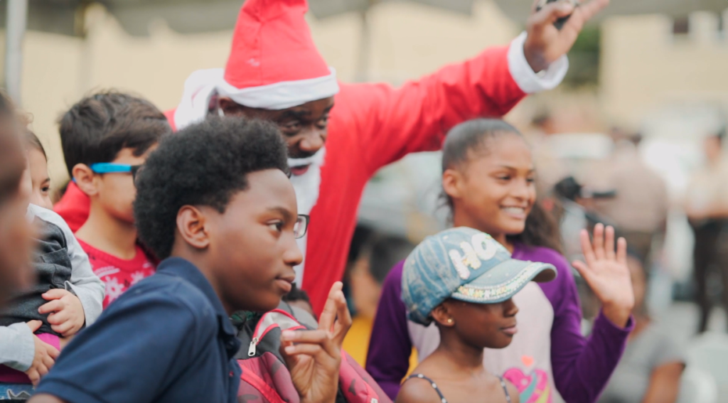 Petland Pembroke Pines picture of Santa Claus taking a picture with a group of children at the Arthur Mays Center Toy Drive.