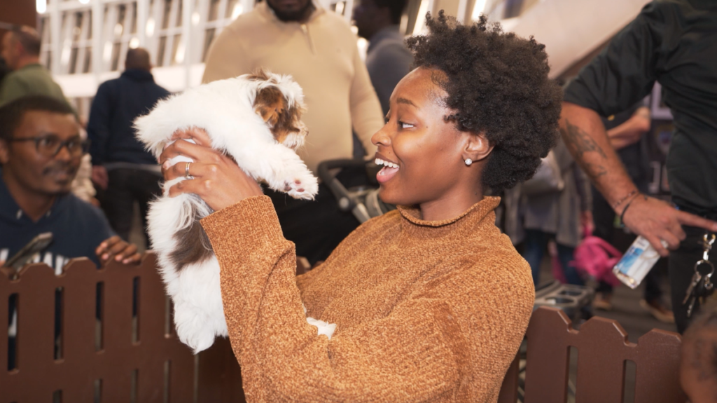 Petland Pembroke Pines picture of a cute puppy from petland being held by a visitor at Children's Holiday in the Pines.