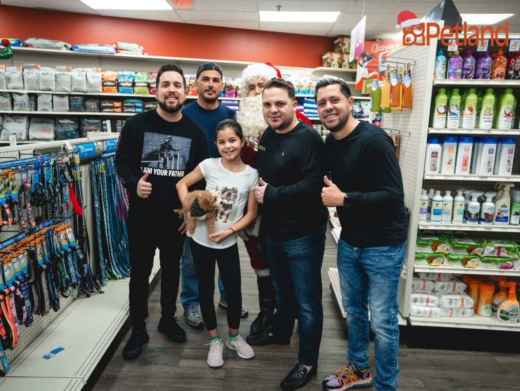 Petland Pembroke Pines picture of Santa Claus, Los Pichy Boys, Luis Marquez and winner of Instagram contest posing with Petland puppy.