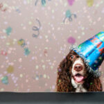 Petland Pembroke Pines picture of cute puppy wearing a New Year's party hat with a confetti background.