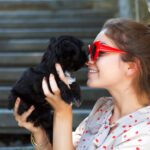 Petland Pembroke Pines picture of a young woman cuddling with her adorable small puppy.