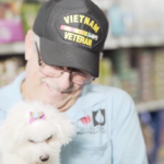 Petland Pembroke Pines picture of Vietnam veteran holding new Bichon Frise puppy.