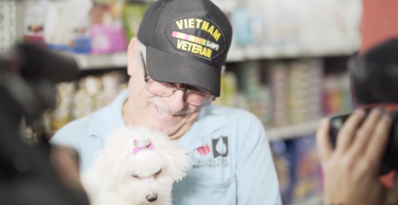 Petland Pembroke Pines picture of Vietnam veteran holding new Bichon Frise puppy.