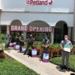 Petland Naples picture of police officers standing with bags of dog food in front of Petland Naples store.