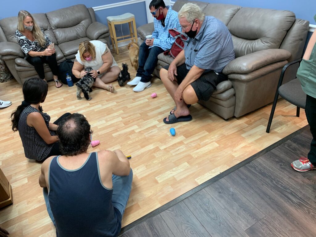 Petland Pembroke Pines picture of NAMI rehab center patients playing with cute Petland puppies for puppy therapy.