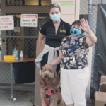 Petland Pembroke Pines picture of Petland staff volunteers and Goldendoodle puppy waving at the camera during Thanksgiving turkey donation.
