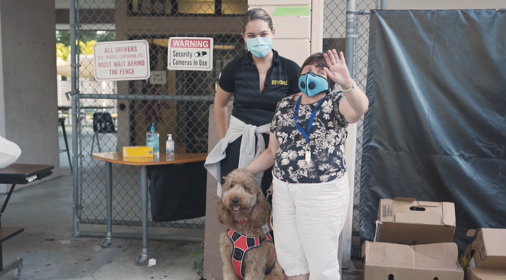 Petland Pembroke Pines picture of Petland staff volunteers and Goldendoodle puppy waving at the camera during Thanksgiving turkey donation.