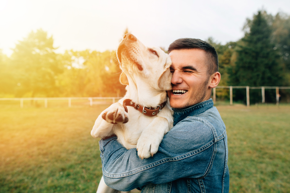 A young man holding his adorable dog.