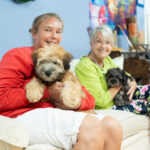 residents of NAMI Center holding cute puppies from Petland Pembroke Pines.