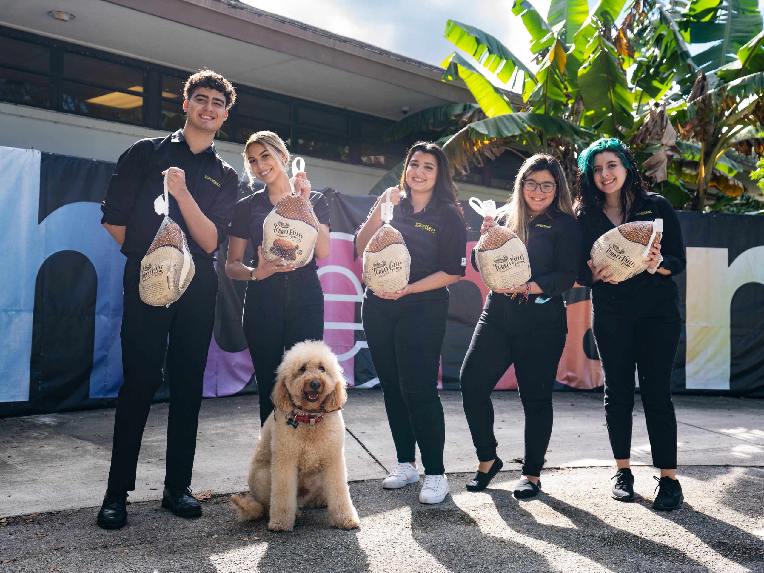 A group of volunteers from Petland Pembroke Pines standing with turkeys for a donation event at the WOW Center.