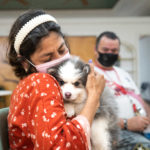 A woman from WOW Center Miami cuddles a cute Pomsky puppy from Petland Pembroke Pines.