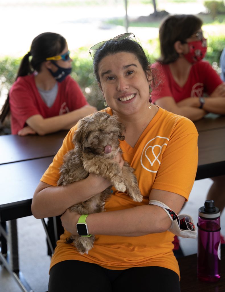 A woman from the WOW Center holds a cute puppy from Petland.